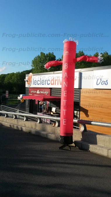 Un skydancer 1 jambe de 4m à l'effigie de la marque banette devant une boulangerie